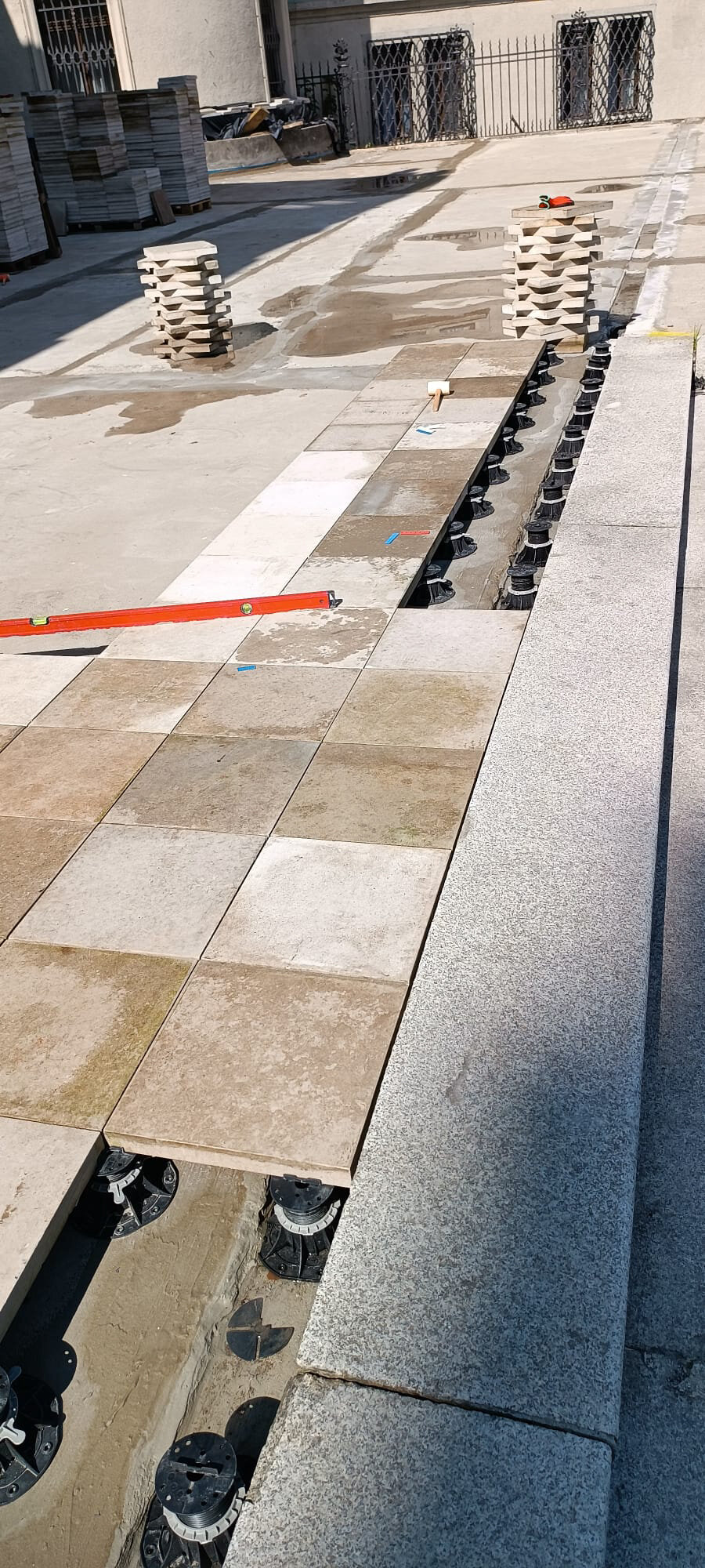Układanie bezowych płyt tarasowych na czarnych wspornikach r