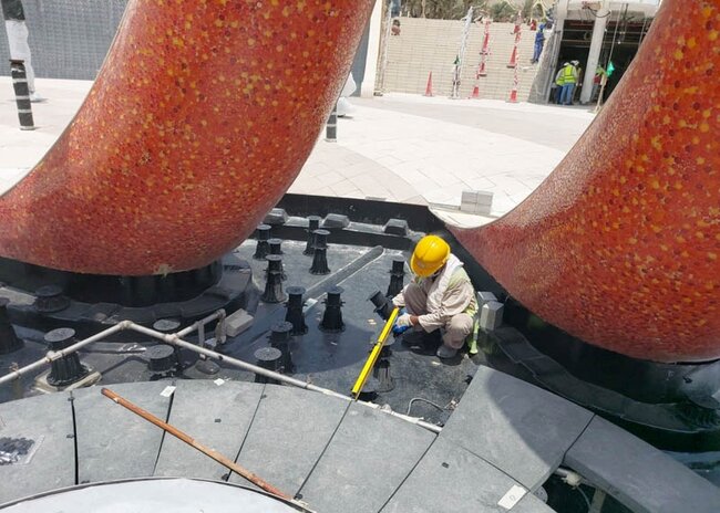Instalador con casco amarillo calibra la altura de los soportes negros