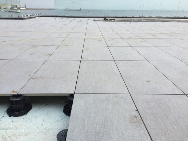 Terraza con suelo técnico sobre plots soporte regulables con baldosas de gres con vistas al mar