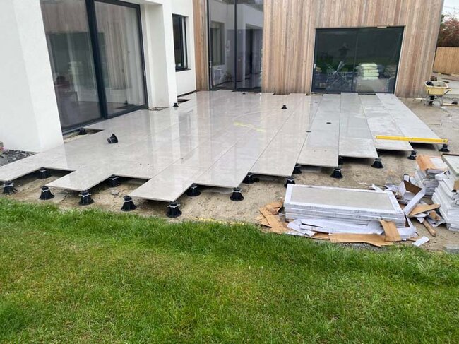 Construcción de terraza con suelo técnico sobre plots soporte con baldosas en terraza de casa particular