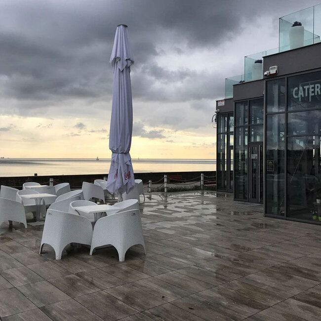 Terraza con suelo técnico con baldosas como jardín de restaurante junto al mar