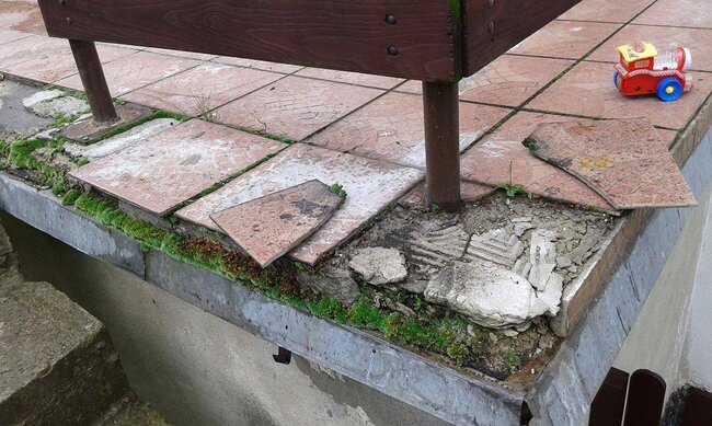 Baldosas que se desprenden y se desmoronan en una terraza tradicional con adhesivo