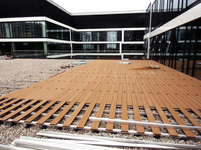 Terraza con suelo técnico en azotea transitable con vigas de aluminio y tablas de composite sobre plots soporte solver