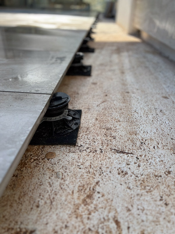 Terraza con plots soporte regulables colocados sobre almohadillas antideslizantes en la terraza