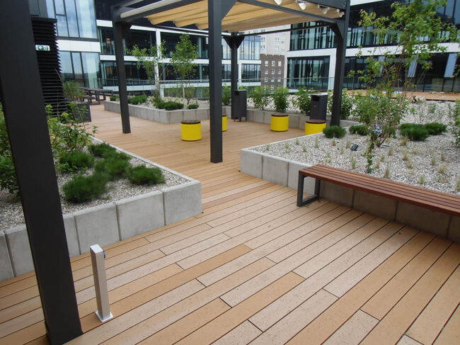 Espacio público en terraza con suelo técnico en la azotea sobre plots soporte con tabla de composite