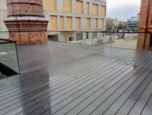 Terraza de composite junto a estructuras históricas