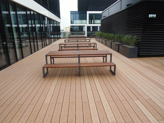 Benches in the common space on a raised deck terrace on pedestals and boards
