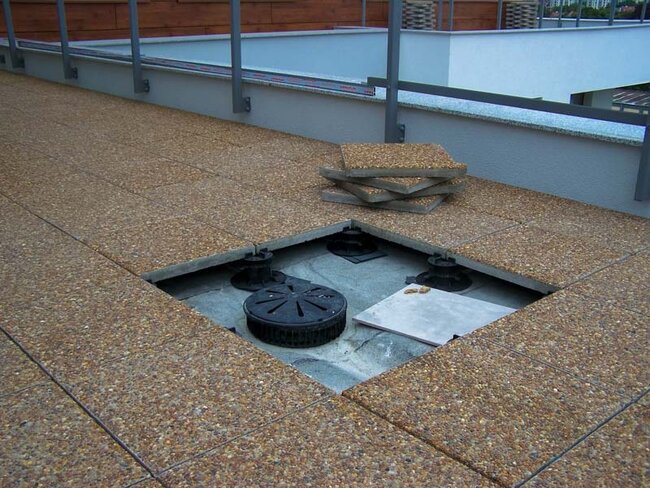 Revisión de baldosas de hormigón en terraza con suelo técnico en la ventilación