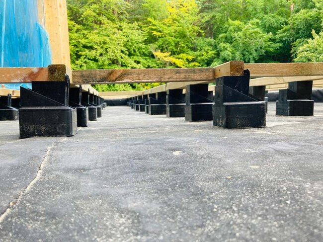 Soportes Raptor que soportan vigas de madera en terraza con suelo técnico