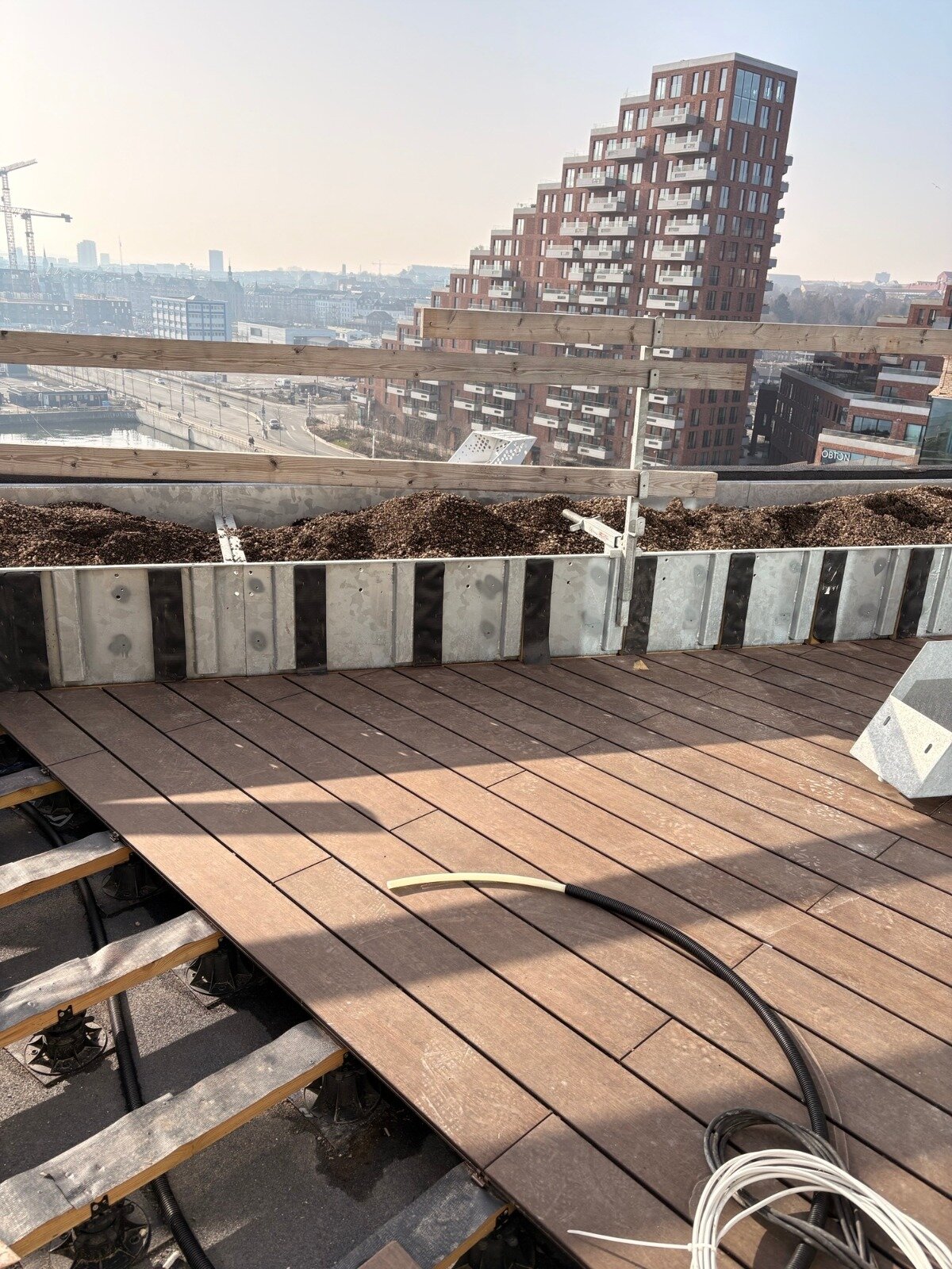 Natural wood planks on the hotel roof with a view, installation on adjustable Solver pedestals