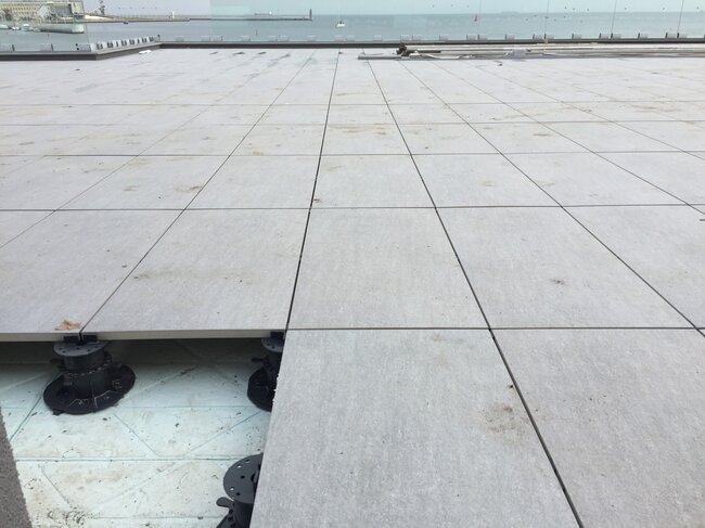 Terraza con suelo técnico en una localidad costera realizada con baldosas colocadas sobre plots soporte regulables