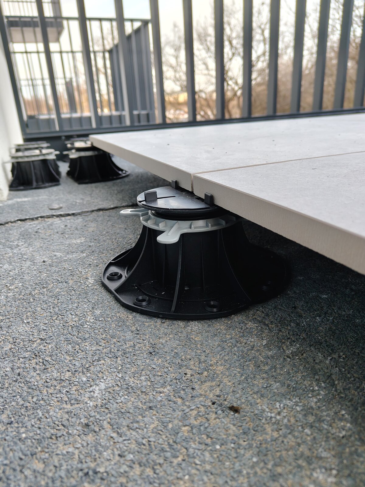 Soporte regulable estándar bajo baldosa de terraza colocado sobre membrana impermeabilizante termofusionada