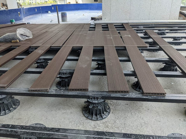 Terraza con tablas de composite con muebles y brasero en el jardín.