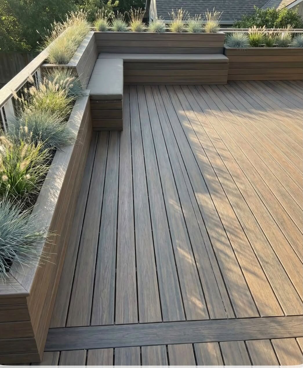 Terraza con tablas de composite con olivos en macetas.