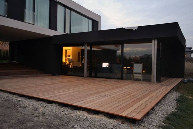 Modern terrace with wooden boards and sliding windows.