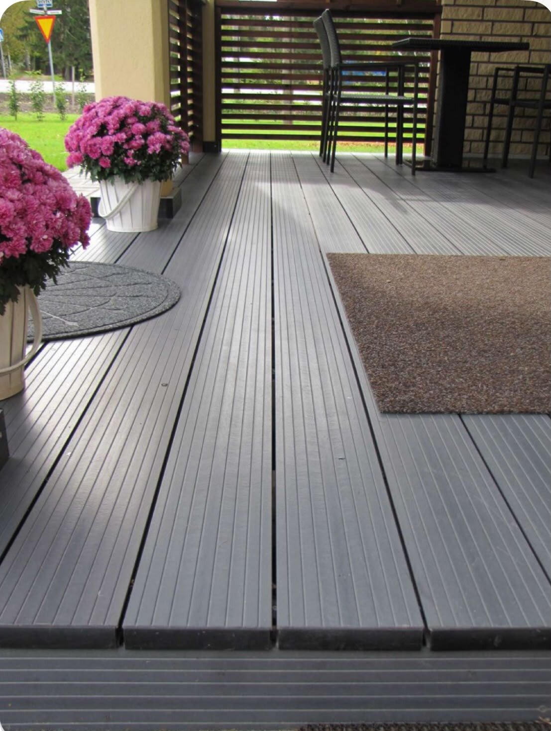 Terraza con tabla de madera con olivo y banco de jardín.