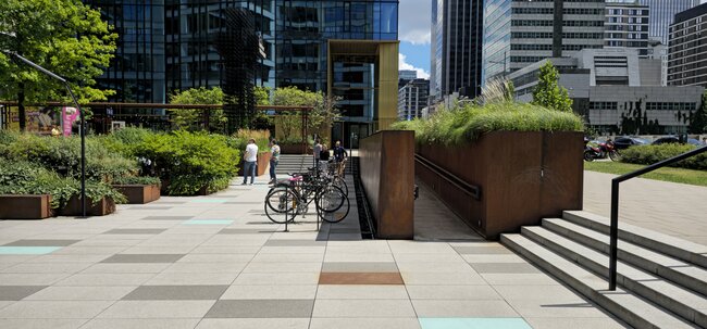 Baldosas de terraza de gran formato en una plaza pública frente a un moderno edificio de oficinas.