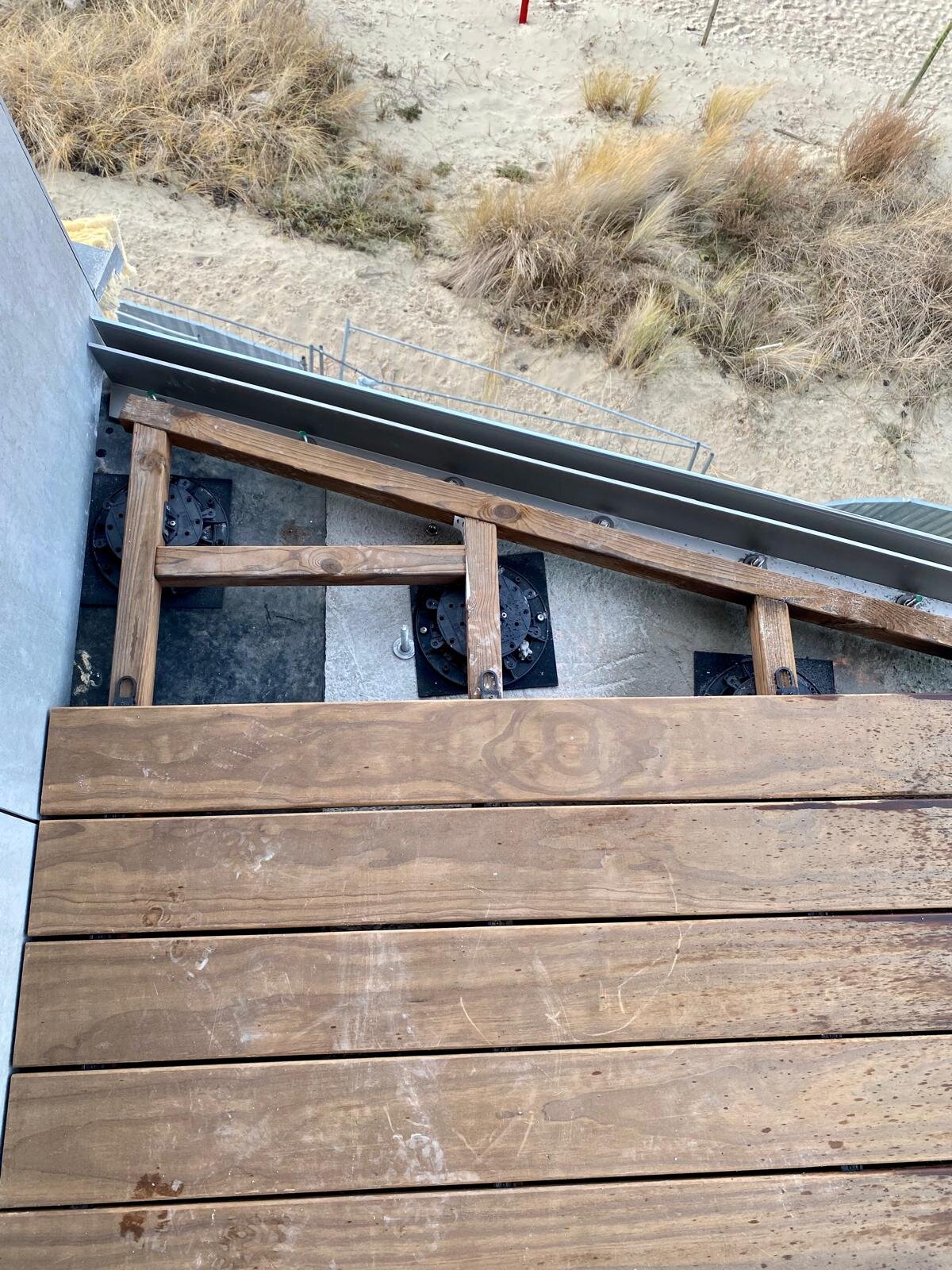 Montaje de terraza de madera sobre plots soporte regulables con vistas a las dunas