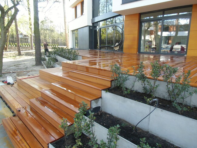Cascada terraza con suelo técnico de tablas exóticas y escaleras de jardín de madera.