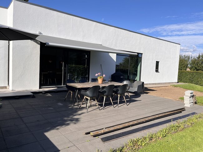 Modern terrace with concrete slabs by a white house