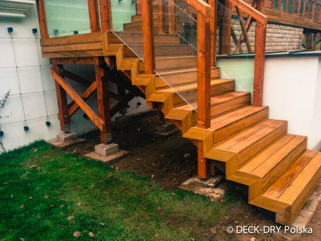 Escaleras de terraza de madera con barandilla de vidrio sobre soportes regulables