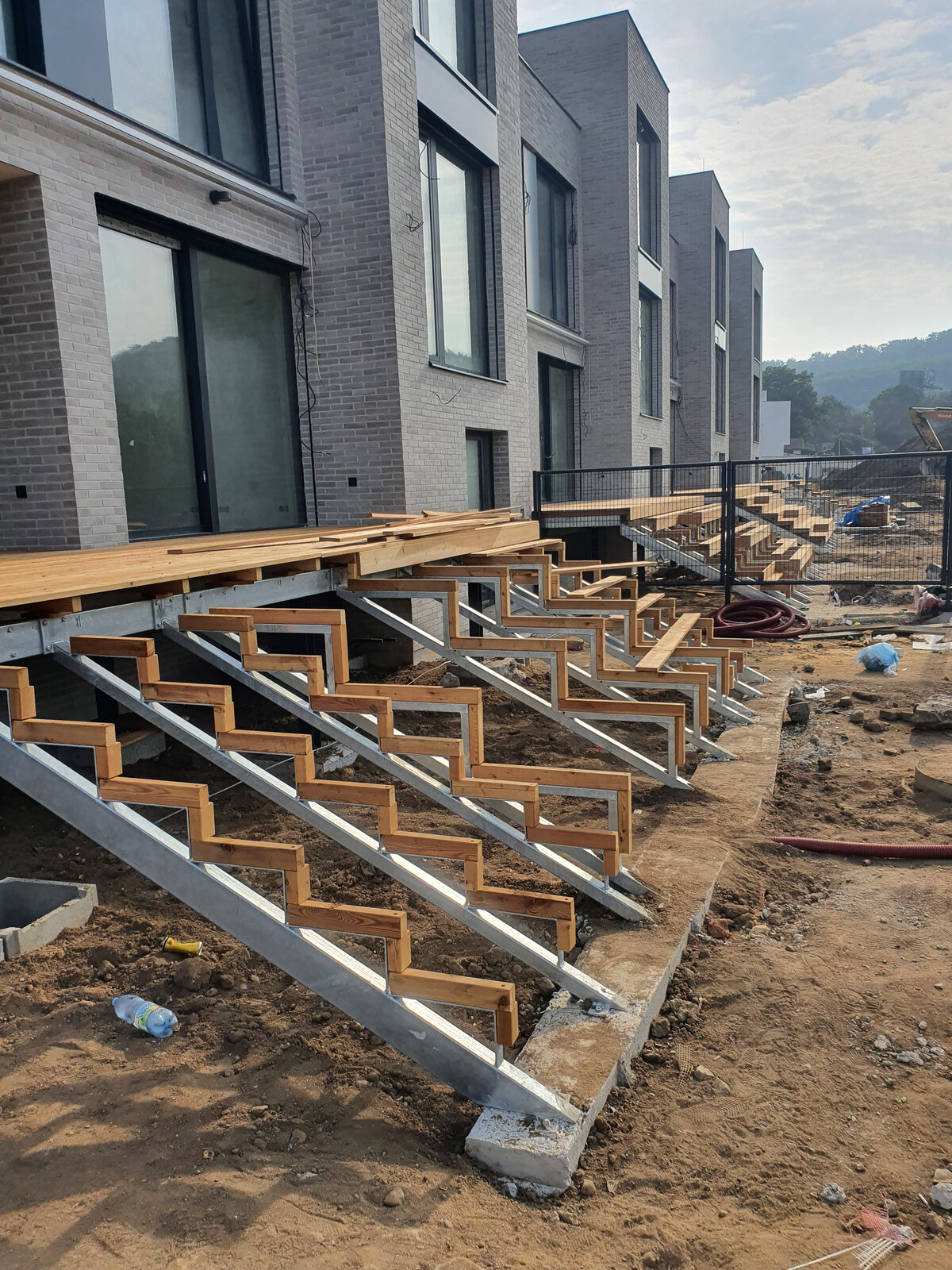 Construcción de escaleras exteriores de terraza sobre vigas de acero y madera