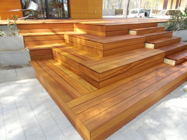 Terraza de madera moderna con escaleras en cascada y maceteros de hormigón
