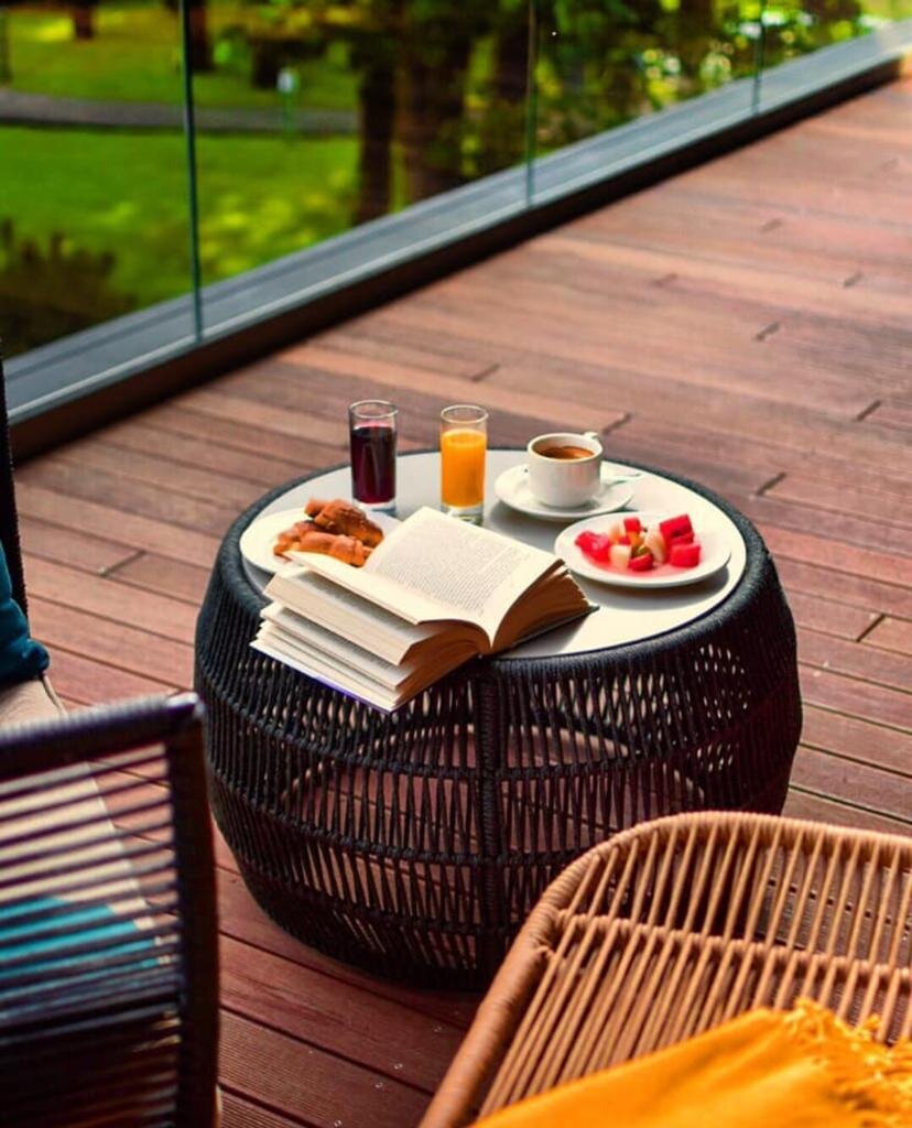 Mesa de café y muebles de jardín en una moderna terraza de madera