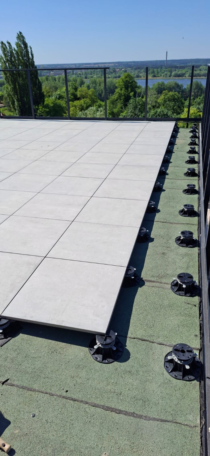 Montaje de terraza con suelo técnico con baldosas cerámicas sobre plots soporte regulables