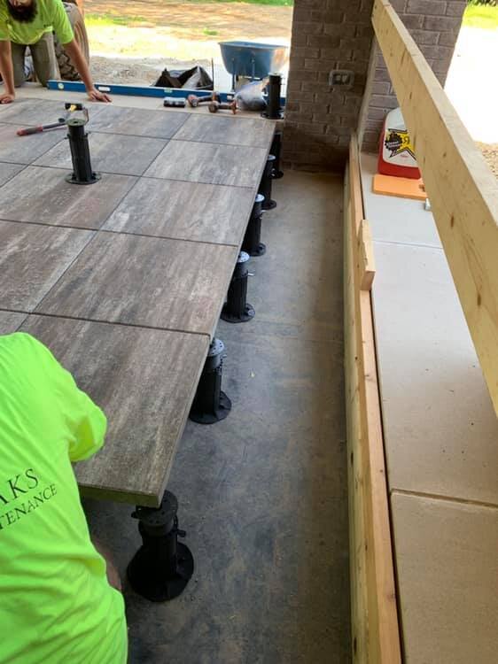 Montaje de suelo elevado con baldosas de hormigón sobre soportes regulables