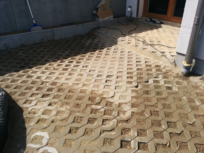 Sustrato para terraza hecho de baldosas de hormigón perforadas rellenas de arena