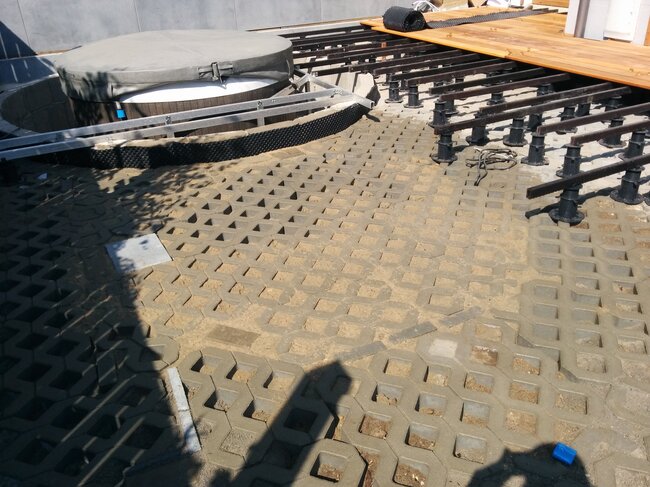 Construcción de terraza de madera sobre vigas y plots soporte con bañera de jardín integrada