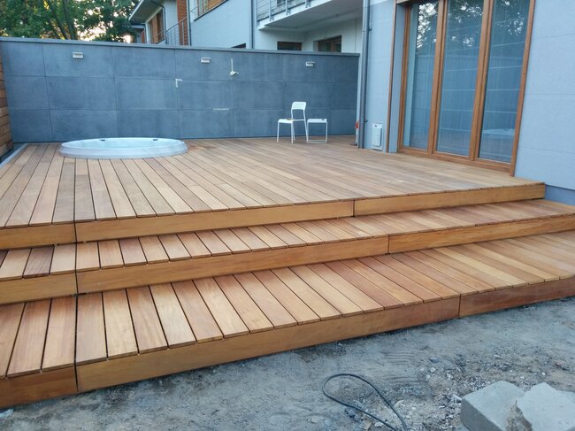 Terraza de madera moderna con escaleras y balneario SPA de jardín integrado