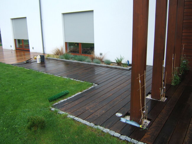 Terraza de madera oscura durante la limpieza y el aceitado