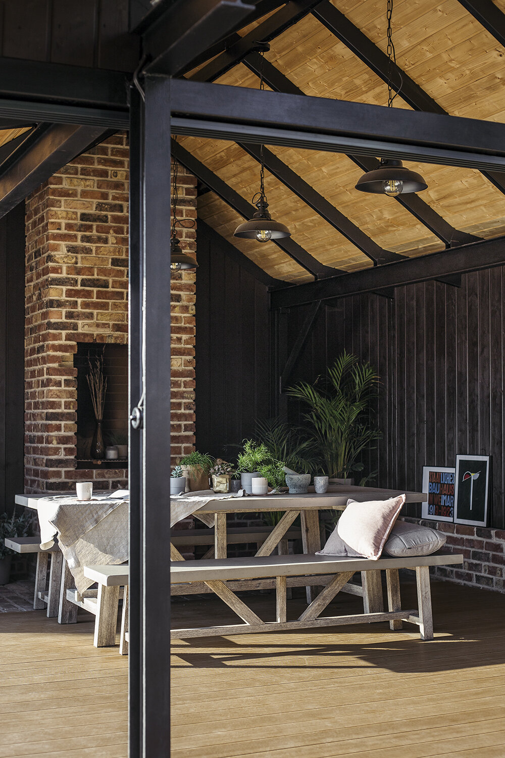 Terraza cubierta con suelo de madera y muebles de jardín
