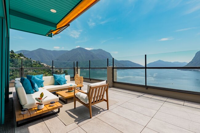 Moderno y elegante terraza con suelo técnico con muebles de descanso y vista al lago