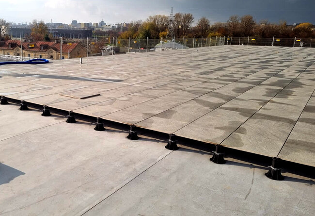 Terraza con suelo técnico en la azotea del edificio acabada con baldosas sobre plots soporte