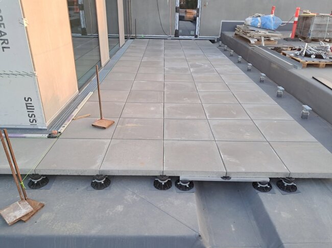 Terraza con suelo técnico larga con baldosas cerámicas grises con barandilla
