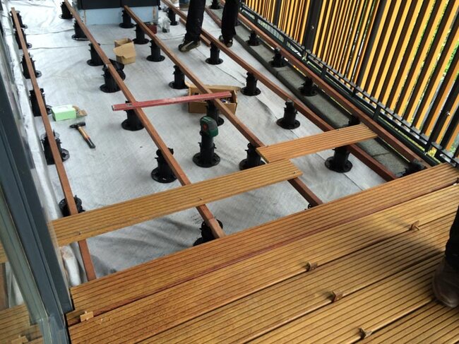 Montaje de terraza con suelo técnico con baldosas de gres sobre plots soporte regulables