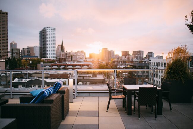 Terraza moderna en la azotea con muebles de jardín y vista panorámica de la ciudad