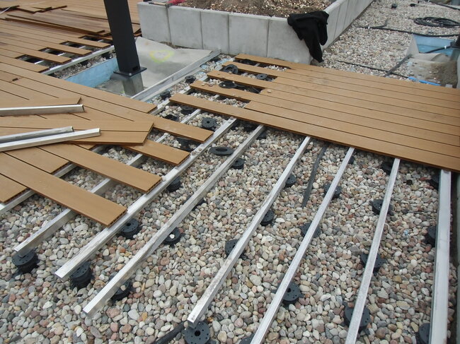 Construcción de terraza de madera sobre vigas de aluminio y plots soporte regulables