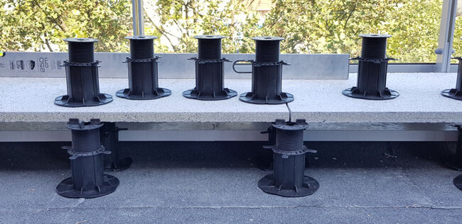 Soportes de terraza regulables colocados bajo las baldosas de terraza