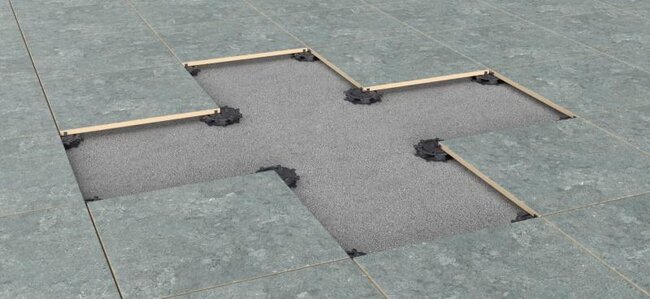 Visualización de terraza con suelo técnico sobre plots soporte regulables con uso de baldosas.