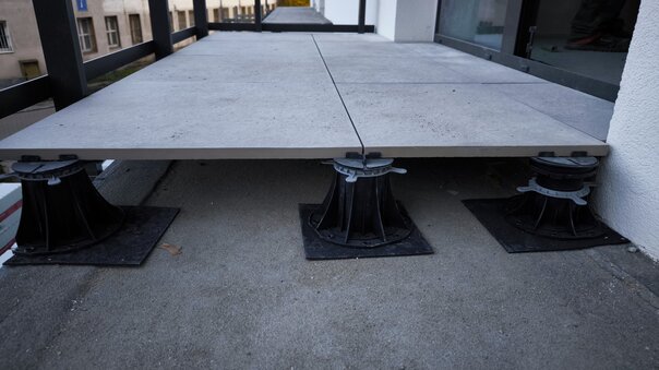 Terraza con suelo técnico de baldosas cerámicas 60x60x2 cm en proceso de instalación.