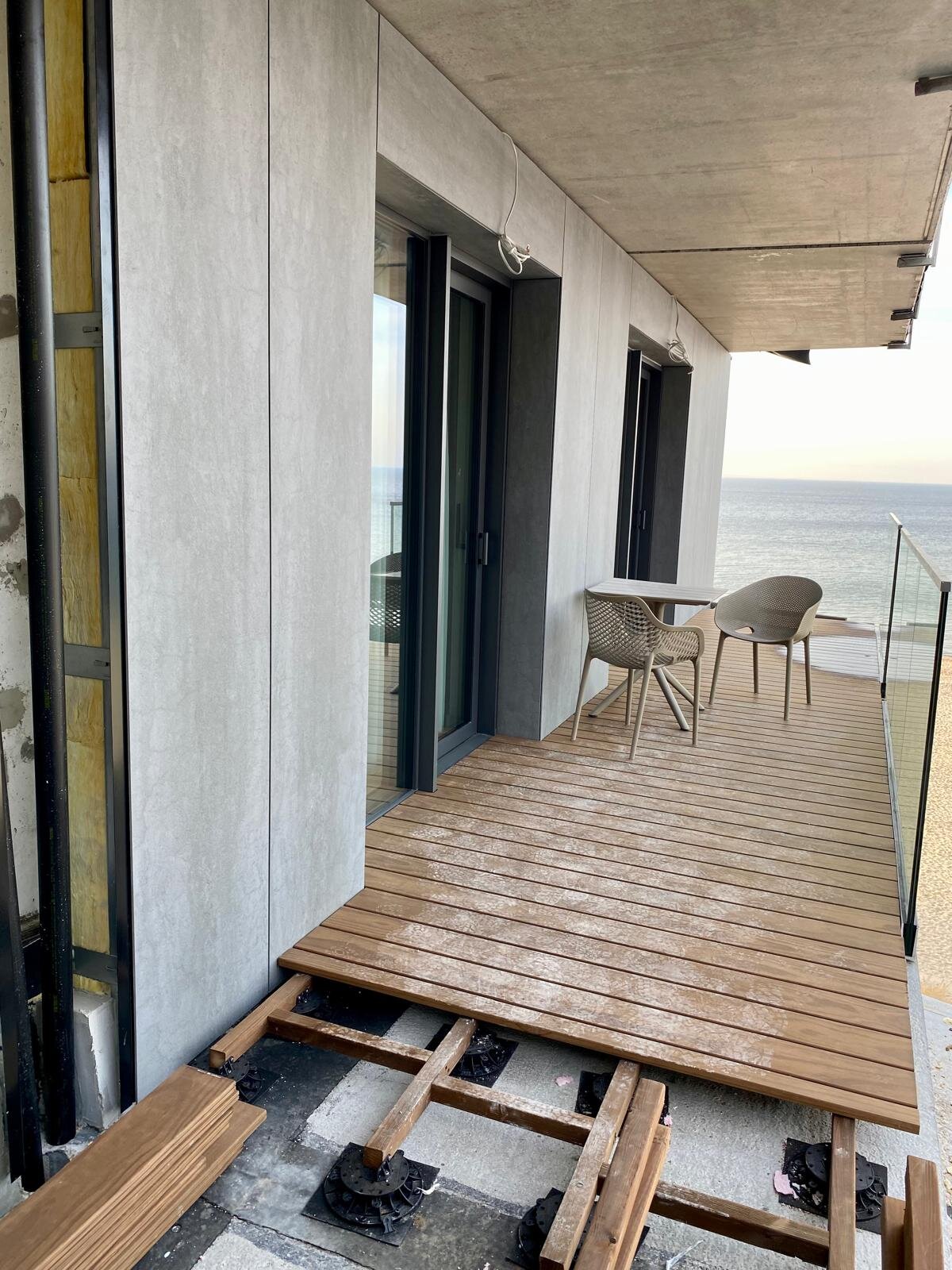 Terraza con suelo técnico en balcón con tablas sobre vigas durante el montaje.