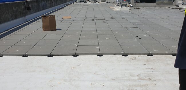 Foto mostrando una terraza colocada sobre soportes de terraza de altura fija.