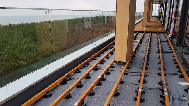 Fotografía de terraza con suelo técnico en la azotea con uso de tablas de terraza sobre vigas