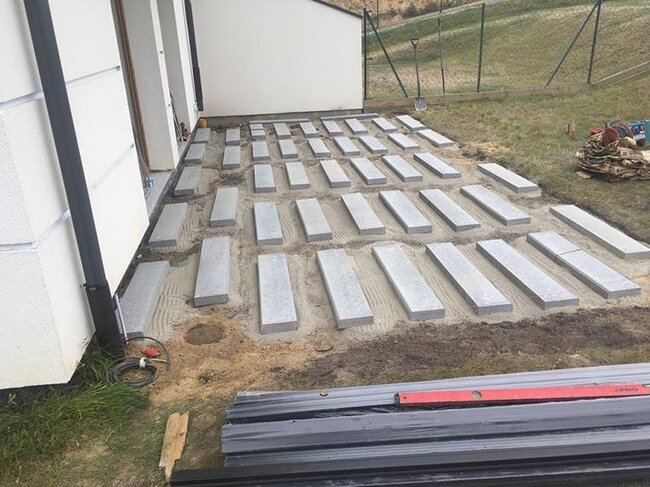 Terraza con suelo técnico sobre el terreno: suelo seleccionado y baldosas de hormigón colocadas y preparadas