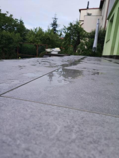 Agua estancada sobre las baldosas en la terraza
