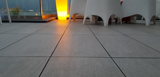 Hueco en terraza con suelo técnico en jardín de restaurante junto al mar
